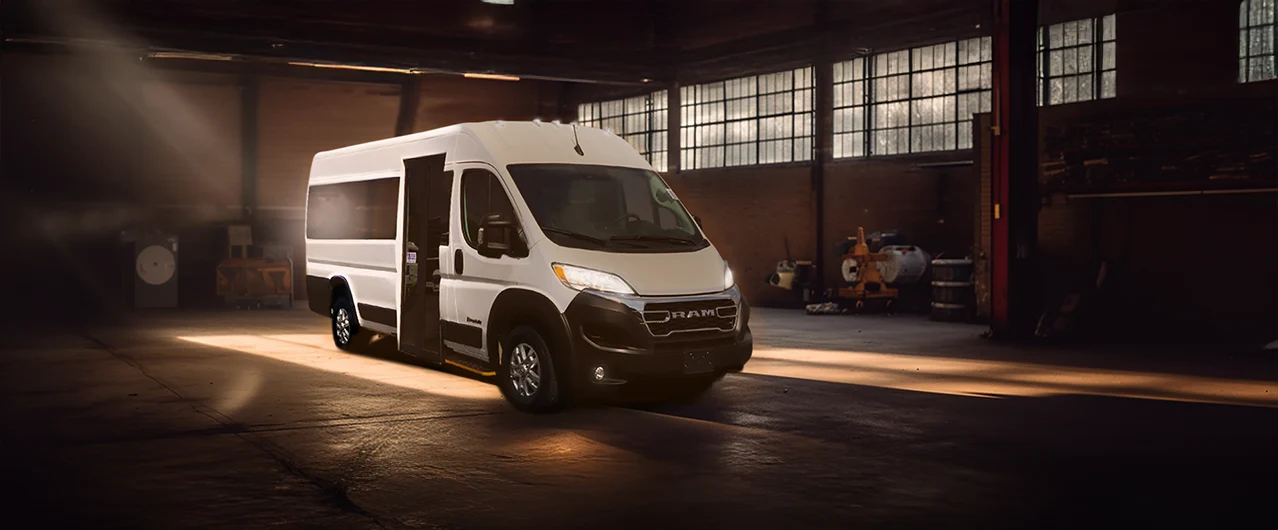 white shuttle bus parked inside a prison garage