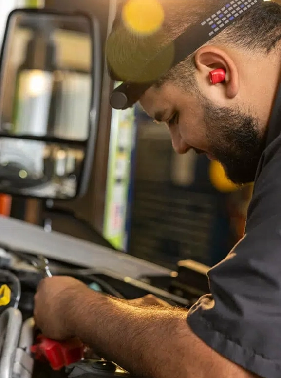 mechanic working on a vehicle with a headlight