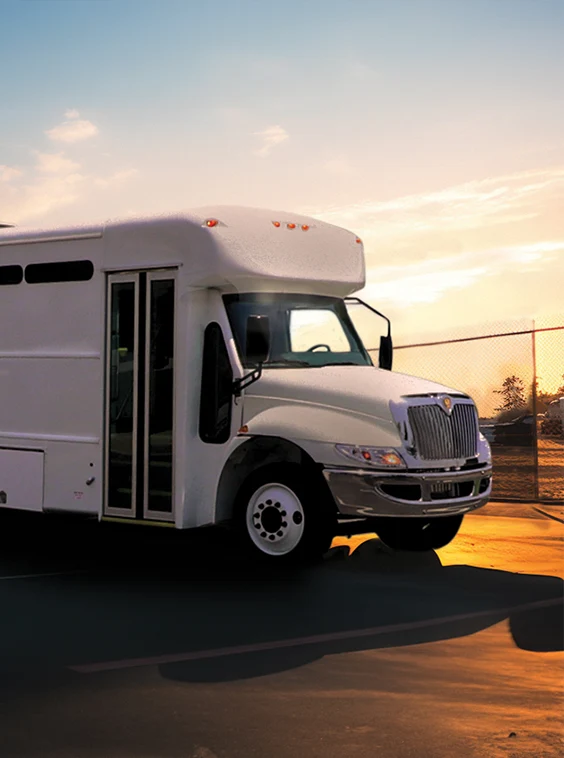 White shuttle bus parked next to a security fence at a prison near Albuquerque